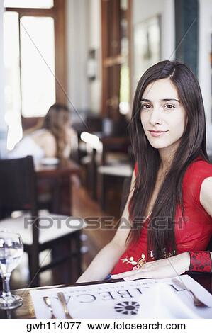 Portrait of a young woman sitting in a restaurant View Large Photo Image Stock Photo - Portrait of a young woman sitting in a restaurant . Fotosearch