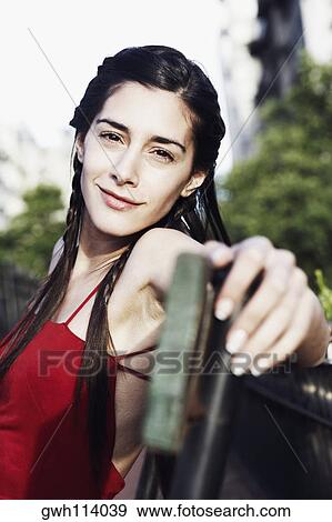 Portrait of a young woman sitting on a bench View Large Photo Image Stock Photo - Portrait of a young woman sitting on a bench . Fotosearch