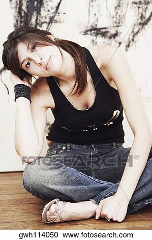 Portrait of a young woman sitting on the floor View Large Photo Image Stock Image - Portrait of a young woman sitting on the floor. Fotosearch