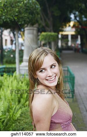 Side profile of a young woman smiling View Large Photo Image Stock Photo - Side profile of a young woman smiling. Fotosearch
