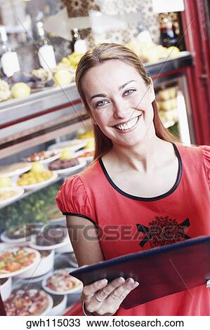 Close-up of a young woman reading a menu in a restaurant View Large Photo Image Stock Image - Close-up of a young woman reading a menu in a restaurant . Fotosearch