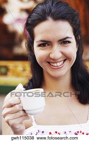 Portrait of a mid adult woman holding a cup of coffee View Large Photo Image Stock Photo - Portrait of a mid adult woman holding a cup of coffee. Fotosearch
