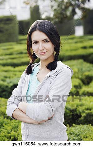 Portrait of a mid adult woman standing in a garden View Large Photo Image Picture - Portrait of a mid adult woman standing in a garden . Fotosearch