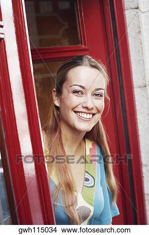 Picture - Portrait of a young woman looking out of a window . Fotosearch