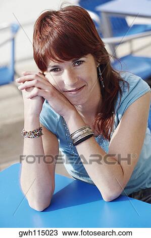 Portrait of a young woman sitting at a sidewalk cafe View Large Photo Image Stock Image - Portrait of a young woman sitting at a sidewalk cafe . Fotosearch