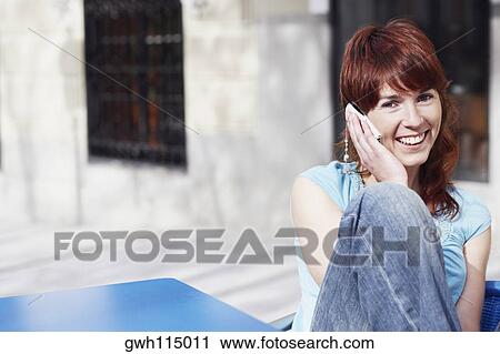 Stock Image - Portrait of a young woman talking on a mobile phone . Fotosearch