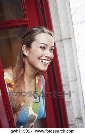 Side profile of a young woman looking out of a window View Large Photo Image Stock Photo - Side profile of a young woman looking out of a window . Fotosearch