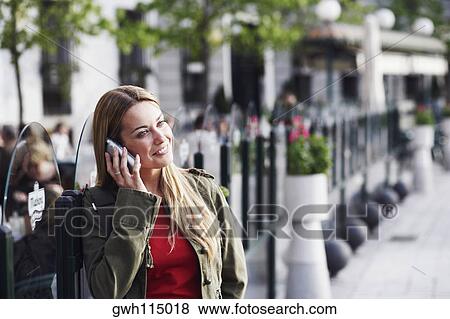 Young woman talking on a mobile phone View Large Photo Image Stock Photo - Young woman talking on a mobile phone . Fotosearch