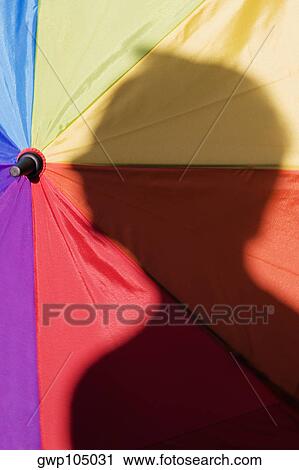 Close-up of a person's shadow on a colorful umbrella View Large Photo Image Stock Image - Close-up of a person's shadow on a colorful umbrella. Fotosearch