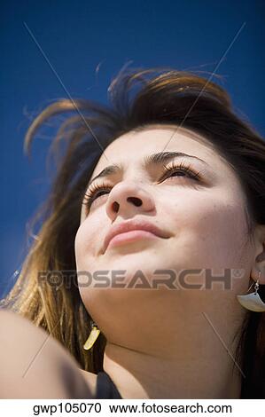 Close-up of a young woman looking away View Large Photo Image Stock Image - Close-up of a young woman looking away. Fotosearch