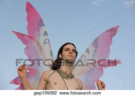 Low angle view of a bare chested gay man in a fairy costume View Large Photo Image Stock Image - Low angle view of a bare chested gay man in a fairy costume. Fotosearch
