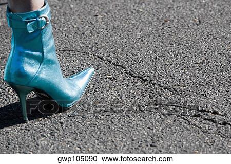 Stock Image - Low section view of a person's leg wearing stiletto boots. Fotosearch