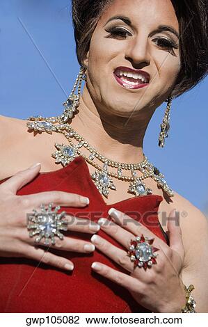 Stock Image - Portrait of a gay man wearing jewelry and smiling. Fotosearch