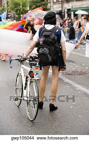 Rear view of a schoolgirl with a bicycle at a gay parade View Large Photo Image Picture - Rear view of a schoolgirl with a bicycle at a gay parade. Fotosearch
