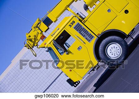 Close-up of a crane on a road in front of a building View Large Photo Image Stock Image - Close-up of a crane on a road in front of a building. Fotosearch