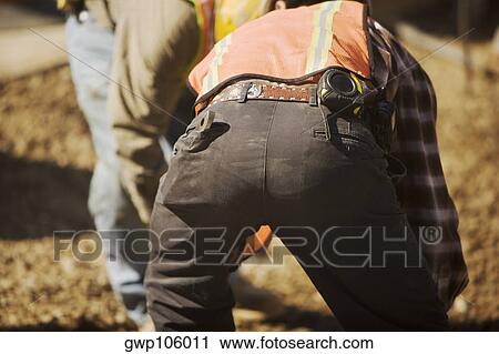 Stock Image - Close-up of two construction workers working at a construction site. Fotosearch