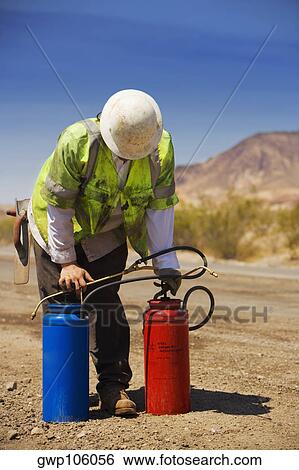 Construction worker holding two cylinders View Large Photo Image Stock Photograph - Construction worker holding two cylinders. Fotosearch