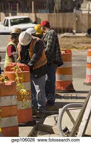 Stock Photograph - Five construction workers working at a construction site. Fotosearch