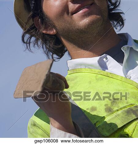 Mid section view of a construction worker holding a hand tool View Large Photo Image Stock Photo - Mid section view of a construction worker holding a hand tool. Fotosearch