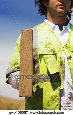 Mid section view of a construction worker holding a hand tool View Large Photo Image Stock Photo - Mid section view of a construction worker holding a hand tool. Fotosearch