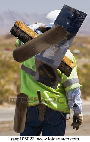 Rear view of a construction worker carrying hand tools on his shoulder View Large Photo Image Stock Image - Rear view of a construction worker carrying hand tools on his shoulder. Fotosearch