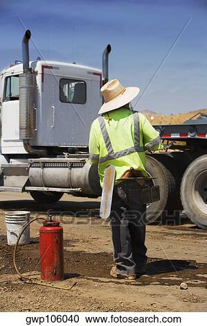 Rear view of a construction worker standing in front of a cement truck View Large Photo Image Stock Image - Rear view of a construction worker standing in front of a cement truck. Fotosearch