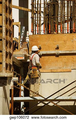 Rear view of a worker at a construction site View Large Photo Image Stock Image - Rear view of a worker at a construction site. Fotosearch
