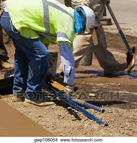 Three construction workers working at a construction site View Large Photo Image Picture - Three construction workers working at a construction site. Fotosearch