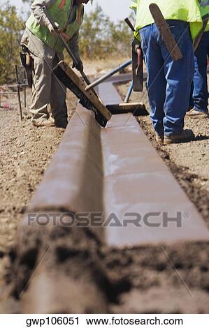 Three construction workers working at a construction site View Large Photo Image Stock Image - Three construction workers working at a construction site. Fotosearch