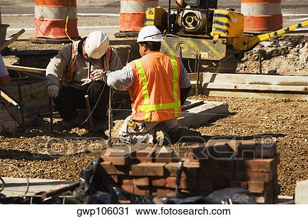 Two construction workers working at a construction site View Large Photo Image Stock Image - Two construction workers working at a construction site. Fotosearch