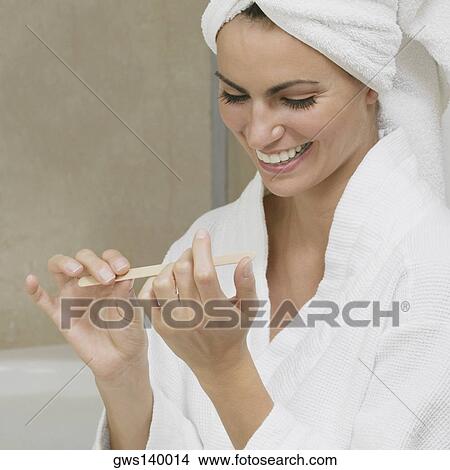 Close-up of a young woman filing her fingernails View Large Photo Image Picture - Close-up of a young woman filing her fingernails. Fotosearch