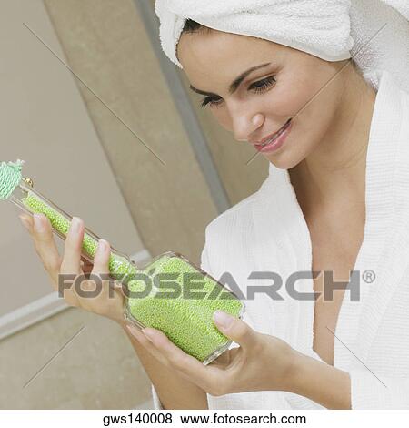 Close-up of a young woman holding a bottle of bath crystals View Large Photo Image Stock Photo - Close-up of a young woman holding a bottle of bath crystals. Fotosearch