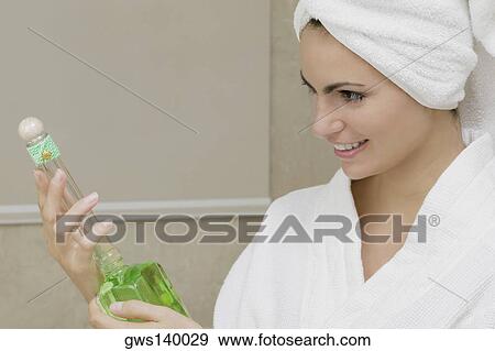 Stock Photo - Close-up of a young woman holding a bottle of aromatherapy oil. Fotosearch