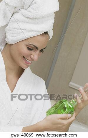 Close-up of a young woman holding a bottle of aromatherapy oil View Large Photo Image Stock Photo - Close-up of a young woman holding a bottle of aromatherapy oil. Fotosearch