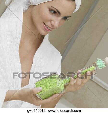 Close-up of a young woman holding a bottle of bath crystals View Large Photo Image Stock Photograph - Close-up of a young woman holding a bottle of bath crystals. Fotosearch