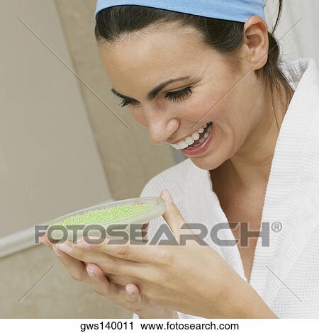 Close-up of a young woman looking at a dish of bath crystals View Large Photo Image Stock Image - Close-up of a young woman looking at a dish of bath crystals. Fotosearch