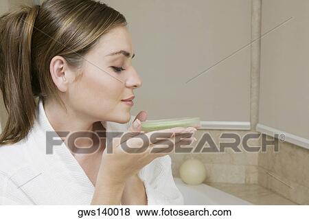 Stock Photo - Close-up of a young woman smelling a dish of bath crystals. Fotosearch