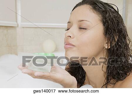 Stock Photo - Side profile of a teenage girl holding a soap dish. Fotosearch