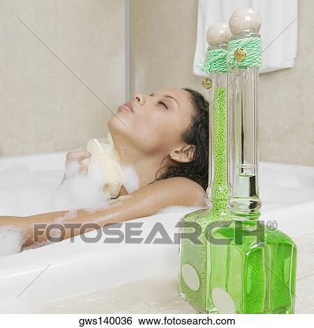 Side profile of a teenage girl scrubbing her body in the bathtub View Large Photo Image Stock Photograph - Side profile of a teenage girl scrubbing her body in the bathtub. Fotosearch