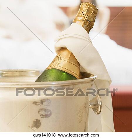 Stock Photo - Close-up of a champagne bottle in an ice bucket. Fotosearch