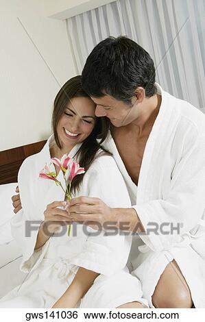 Stock Photograph - Close-up of a mid adult man giving flowers to a young woman. Fotosearch