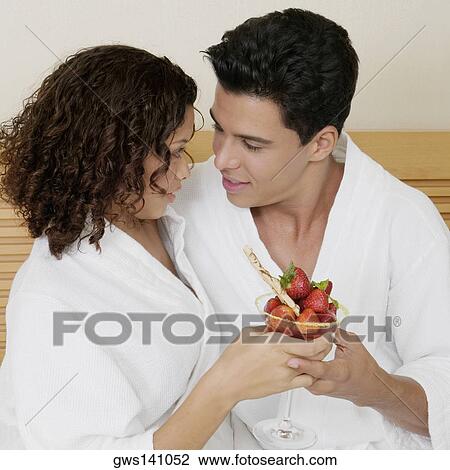 Close-up of a young man and a teenage girl holding a glass of strawberries View Large Photo Image Stock Image - Close-up of a young man and a teenage girl holding a glass of strawberries. Fotosearch