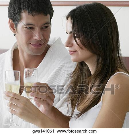 Close-up of a young woman and a mid adult man toasting with champagne flutes View Large Photo Image Stock Image - Close-up of a young woman and a mid adult man toasting with champagne flutes. Fotosearch
