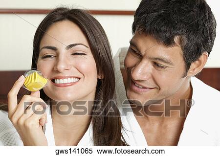 Close-up of a young woman holding a cupcake with a mid adult man looking at her View Large Photo Image Stock Photography - Close-up of a young woman holding a cupcake with a mid adult man looking at her. Fotosearch