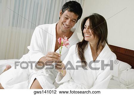 Mid adult man giving flowers to a young woman View Large Photo Image Stock Image - Mid adult man giving flowers to a young woman. Fotosearch