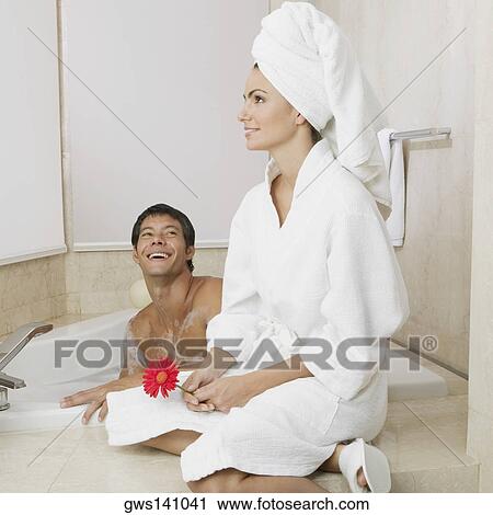 Mid adult man looking at a young woman sitting near him in the bathtub View Large Photo Image Stock Image - Mid adult man looking at a young woman sitting near him in the bathtub . Fotosearch