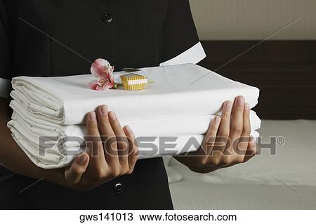 Mid section view of a woman holding sheets View Large Photo Image Stock Image - Mid section view of a woman holding sheets. Fotosearch