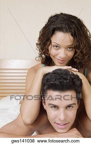 Portrait of a teenage girl lying on top of a young man on the bed View Large Photo Image Stock Photo - Portrait of a teenage girl lying on top of a young man on the bed. Fotosearch