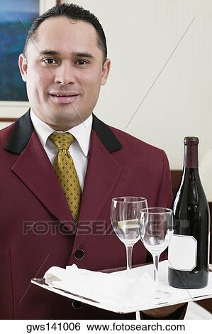 Portrait of a waiter holding a tray with a wine bottle and two wineglasses View Large Photo Image Stock Photograph - Portrait of a waiter holding a tray with a wine bottle and two wineglasses. Fotosearch