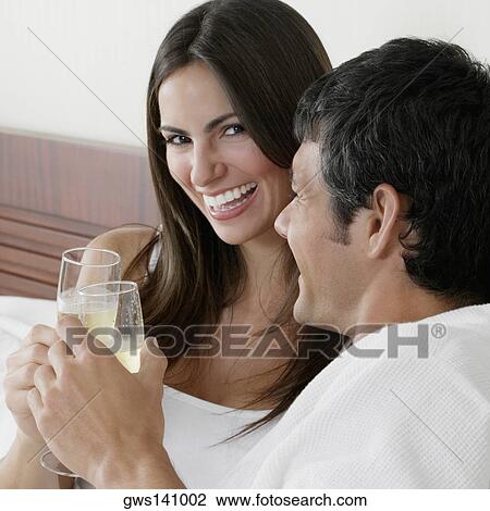 Portrait of a young woman and a mid adult man toasting with champagne flutes View Large Photo Image Stock Image - Portrait of a young woman and a mid adult man toasting with champagne flutes. Fotosearch